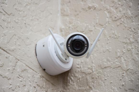 caméra de surveillance blanche accrochée au mur