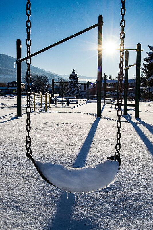 balançoire à l'aire de jeux couverte de neige