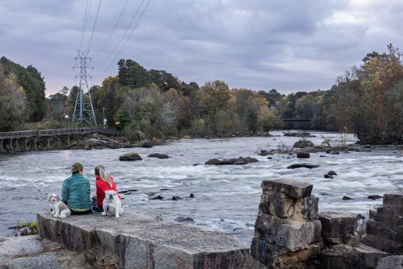 deux femmes avec des chiens au bord de la rivière